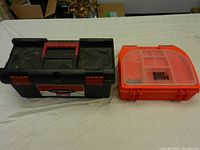 Closed view of two toolboxes on table, one black Husky and one orange Black & Decker