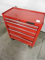 Front angled view of the red Waterloo tool chest showing all five closed drawers spaced with aluminum handles, top surface, and caster wheels.