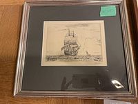 Framed print of sailing ship on the ocean with a silver frame and dark matte
