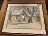 Front view of the framed lithograph artwork by Jack Reid showing the snow-covered stone house scene.