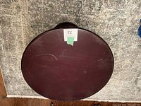 Top view of round wooden table showing surface scratches and wear.
