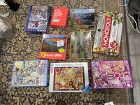 Image showing eight puzzle boxes of mostly 1000 pieces and one Monopoly Super Mario board game box.