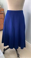 Full front view of blue wool knit skirt on mannequin, showing flare and waistband