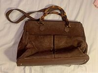Front and side view of entire brown suede and leather handbag with bamboo handles and shoulder strap