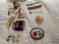 Overview of vintage collection including brooches, earrings, hair pins, and lighter