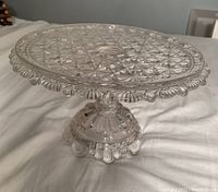 Side angle photo showing the detailed starburst pattern on the cake stand's surface and the scalloped edge with the pedestal base.