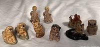 Overview of all 9 Wade England and other figurines including animals and human figures, arranged on white background.