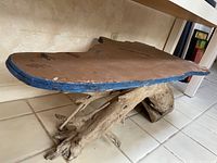 Side angle showing driftwood base and blue-edged irregular top with peeling surface.
