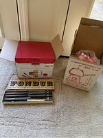 Opened view of fondue condiments set in original packaging, with multiple fondue forks and equipment visible.