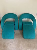 Front view of both chairs with matching ottomans side by side.