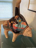 Three-quarter front view showing full bison sculpture with rider motif and overall shape.