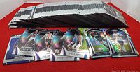 Wide shot showing a large stack of Panini Prism Premier League soccer cards with several cards fanned out in front showing holographic and parallel designs.