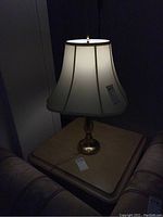 Two matching table lamps on a side table, one lamp lit, showing overall shape and height.