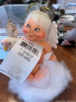 Close up of 7-inch Wings of Hope Angel doll with golden halo, white hair, cotton cloud base, and smiling face.