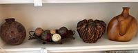 Group view showing four main items: ceramic vase, wood vase, wood basket-style vase, metal bowl with decorative balls.