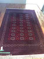 Overhead view of red oriental style area rug on hardwood floor