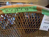 Close-up photograph showing dimension labels on the backrest of the wicker chair measuring 25" width, 18" depth, and 42" height