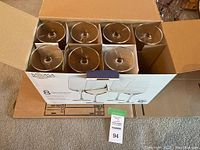 Open box containing 7 clear stemmed wine glasses from ASA Selection brand with a total capacity shown as 16.5 oz on packaging.