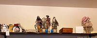 Photo of shelf with assorted collectibles including dog figurines, paper mache art, and crosses