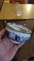 Porcelain bowl held in hand showing floral blue design pattern