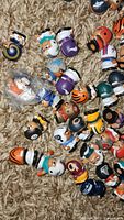 Small NFL player figurines in various team uniforms scattered on carpet, some in zip lock bags.