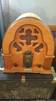 Front view of the wooden vintage-style Thomas Collector's Edition radio showing carved speaker grill and control knobs.