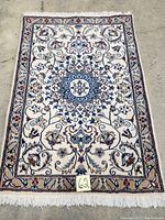 Full view of rectangular carpet displaying field, border, and fringe with tag ‘62’