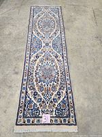 Full view of rectangular runner laid flat, showing overall pattern and fringed end