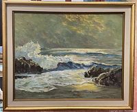 Full view of the vintage oil painting showing ocean waves, rocky shore, and framed presentation.