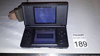 Open black Nintendo DS Lite with screen on showing startup message, control buttons visible on right side