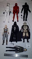 Top-down photo showing all seven Star Wars action figures arranged on a flat surface with a ruler for scale.
