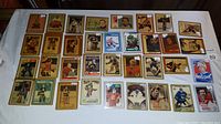 Front side of 35 NHL goalie hockey cards laid out in rows on white surface, showing various players and designs.