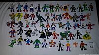 Overview of multiple superhero figures laid flat on light surface showing variety and condition