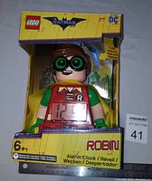 Front view of LEGO Robin alarm clock in original yellow box with Batman Movie branding. Clock display visible on figure's torso.
