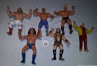 Front view of six vintage wrestling figures with varied attire and poses on white background.