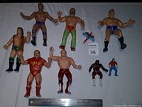 Top view of all 7 figures including bonus thumb wrestler, showing front features, color and size comparison with ruler.