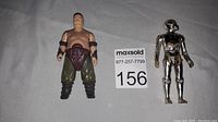 Rancor Keeper and Death Star Droid figures side by side, showing front view.
