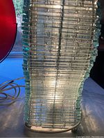 Close-up showing the glass bars with some chipping damage and the wire framework holding them together.