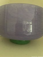 Close-up of the purple glass body of the bowl showing the texture and glossy finish.