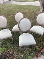 Four chairs arranged outdoors on grass showing full set