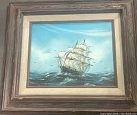 Full view of the framed ship painting showing the entire ship in ocean setting with seagulls and blue sky.