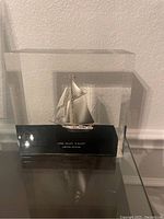 Front view of the sterling silver yacht model in a clear display case with black base