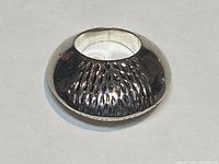 Top view of a 925 silver ring showing textured design with polished finish.