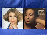 Front view of Aretha Franklin and Roy C vinyl record sleeves side by side showing album art and condition.