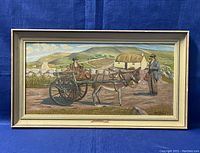 Full view of the framed painting depicting a rural scene with two men, a donkey, and a cart with a stone wall, fields, and a cottage in the background.