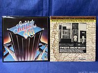 Photo showing the front cover of the Lanier & Co vinyl sleeve and The Legacy of the Blues Sampler sleeve side by side on blue background.