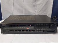 Front and angled view of the Nikko NR-350 stereo receiver showing tuning dial, sliders, buttons, and controls