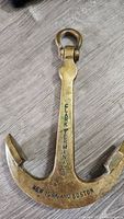 Full view of the brass anchor showing overall shape and 'Clark Terminals New York and Boston' engraving.