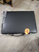 Closed black carrying case with handle containing the cutlery set.