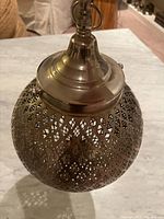 Top down view of the Moroccan pendant lamp showing smooth cap and perforated metal lattice body